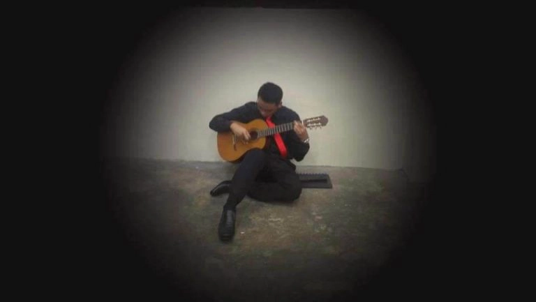 Anwar practising the guitar for a performance